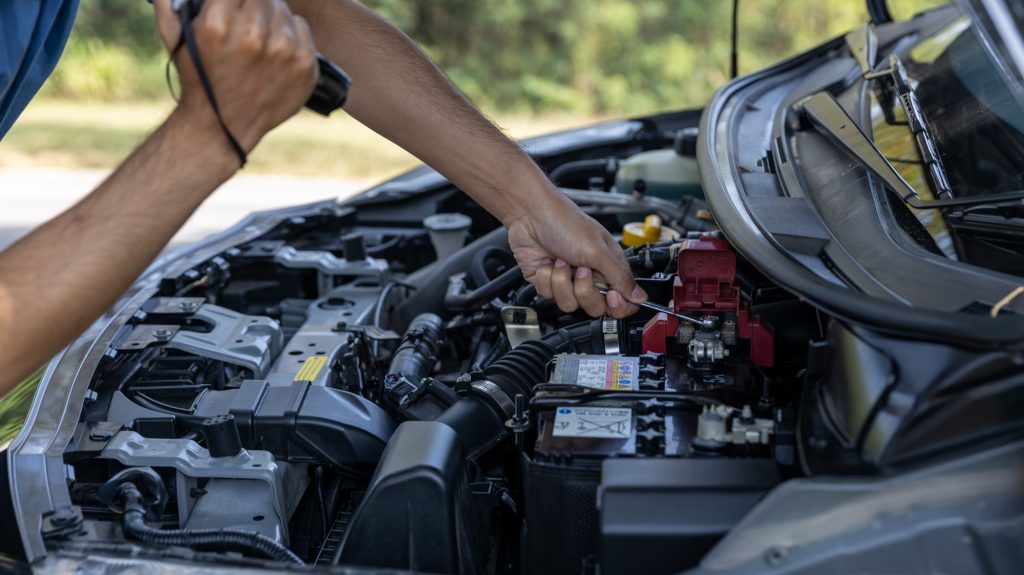 Man is Checking car battery because car battery is depleted. concept car maintenance